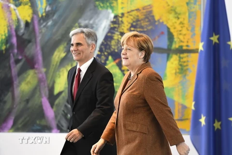 Thủ tướng Áo Werner Fayman (trái) và Thủ tướng Đức Angela Merkel đã cùng lên tiếng bảo vệ chính sách nhập cư và tị nạn trong cuộc họp báo ở thủ đô Berlin của Đức ngày 19/11. (Nguồn: AFP/TTXVN)