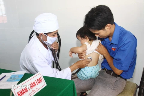 Bác sỹ Trạm y tế xã Triệu Trạch (Quảng Trị) khám phân loại trẻ trước khi tiêm vắcxin Quinvaxem. (Ảnh: Hồ Cầu/TTXVN)