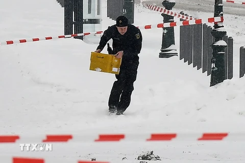 Cảnh sát mang chiếc hộp đựng gói bưu phẩm khả nghi ra khỏi khu vực Văn phòng Thủ tướng Đức ở Berlin. (Nguồn: AFP/TTXVN)