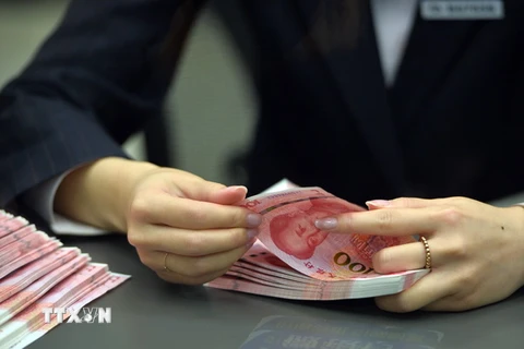 Kiểm đồng nhân dân tệ tại một chi nhánh ngân hàng ở thủ đô Bắc Kinh. (Nguồn: THX/TTXVN)