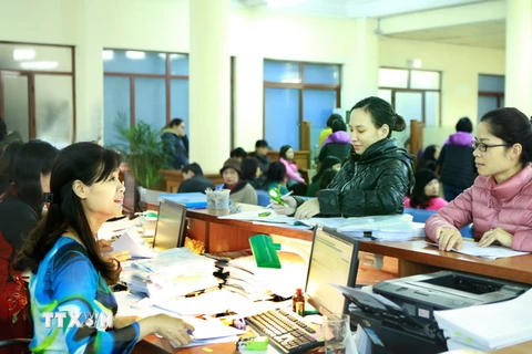 Khách hàng giao dịch tại bộ phận kế toán kiểm soát chi của Kho bạc Nhà nước Hà Nội. (Ảnh: Hoàng Hùng/TTXVN)