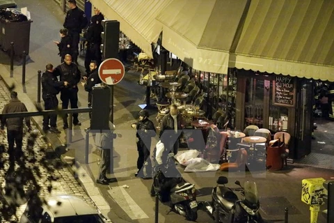 Cảnh sát điều tra tại hiện trường một vụ tấn công khủng bố ở nhà hàng trung tâm Paris ngày 13/11. (Ảnh: AFP/TTXVN)