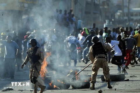 Cảnh hỗn loạn do người biểu tình phản đối việc tổ chức cuộc bầu cử Tổng thống vòng hai gây ra tại thủ đô Port-au-Prince ngày 19/1. (Nguồn: AFP/TTXVN)