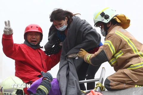 Nhân viên cứu hộ đưa một phụ nữ bị mắc kẹt ra khỏi đống đổ sau trận động đất. (Nguồn: THX/TTXVN)