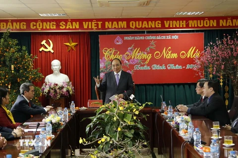 Phó Thủ tướng Nguyễn Xuân Phúc thăm, nói chuyện với cán bộ, nhân viên Ngân hàng Chính sách xã hội Việt Nam. (Ảnh: Trần Việt/TTXVN)