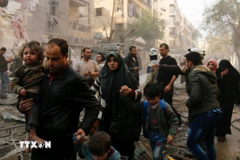 Người dân Syria sơ tán sau các cuộc không kích của quân đội chính phủ vào các mục tiêu của phiến quân ở thành phố Aleppo ngày 13/1. (Nguồn: AFP/TTXVN)