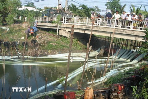 Huy động 21 máy bơm liên tục bơm nước chống hạn tại điểm cầu Hộ trên kệnh Champeaux, xã Tân Thành, Gò Công Đông, Tiền Giang. (Ảnh: Minh Trí/TTXVN)