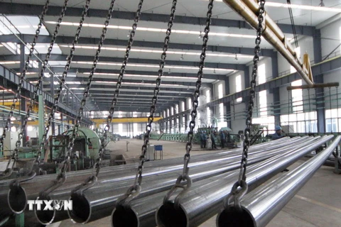 Công nhân kiểm tra ống thép inox chất lượng cao tại nhà máy ở huyện Ganyu, tỉnh Giang Tô, miền đông Trung Quốc ngày 23/5. (Nguồn: THX/TTXVN)