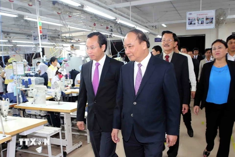 Phó Thủ tướng Nguyễn Xuân Phúc thăm phân xưởng may của Công ty. (Ảnh: Trần Lê Lâm/TTXVN)