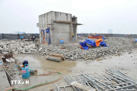 Thực hiện phá dỡ phần công trình xây dựng sai phạm tại tòa nhà 8B Lê Trực (ảnh chụp sáng 6/3). (Ảnh: Minh Đức/TTXVN)