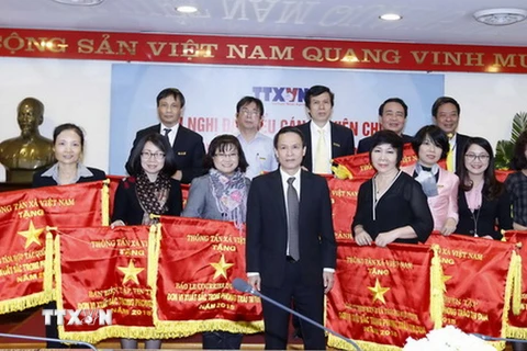 Ông Nguyễn Đức Lợi, Ủy viên Trung ương Đảng, Bí thư Đảng ủy, Tổng Giám đốc TTXVN trao tặng Cờ Thi đua cho các đơn vị. (Ảnh: An Đăng/TTXVN)