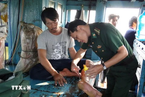 Quân y Biên phòng tỉnh Sóc Trăng chăm sóc sức khỏe cho ngư dân bi nạn. (Ảnh: Trung Hiếu/TTXVN)