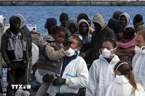Người di cư tới cảng Messina sau khi được Lực lượng bảo vệ bờ biển Italy cứu tại eo biển Sicily ngày 17/3. (Nguồn: AFP/TTXVN)