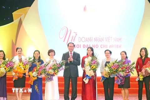 Chủ tịch nước Trần Đại Quang tặng hoa chúc mừng các lãnh đạo nữ khối các bộ, ban ngành Trung ương. (Ảnh: Nhan Sáng/TTXVN)