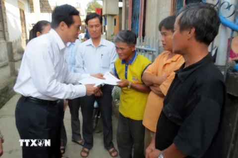 Phó Chủ tịch Ủy ban Trung ương Mặt trận Tổ quốc Việt Nam Lê Bá Trình thăm và tặng quà cho ngư dân. (Ảnh: Quốc Việt/TTXVN)