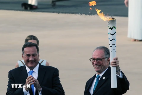 Chủ tịch Ban tổ chức Thế vận hội "RIO 2016" Carlos Nuzman (phải) nhận ngọn đuốc thiêng Olympic 2016 trong buổi lễ tại sân vận động Panathenaic ở thủ đô Athens. (Nguồn: THX/TTXVN)