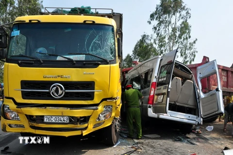 Hiện trường vụ tại nạn, chiếc xe khách bị bẹp dúm, kẹp giữa 2 xe tải. (Ảnh: Đinh Thị Hương/TTXVN)