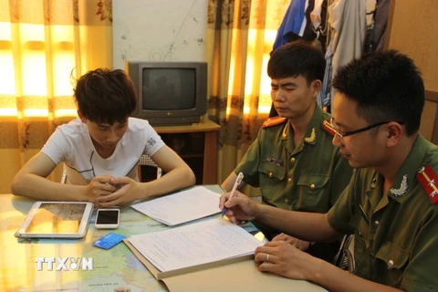 Đối tượng Bùi Đức Hải (áo trắng) bị triệu tập tại cơ quan Công an tỉnh Thái Bình. (Ảnh: Xuân Tiến/TTXVN)
