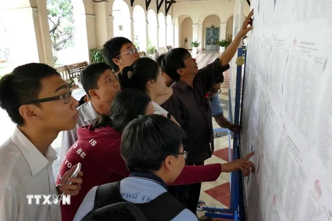 Phụ huynh và học sinh xem kết quả kỳ thi tuyển sinh lớp 10 tại trường THPT Chuyên Lê Hồng Phong. (Ảnh: Phương Vy/TTXVN)