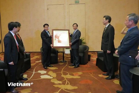 Chủ tịch UBND TP.Hà Nội Nguyễn Đức chung trao quà kỷ niệm cho Thị trưởng thành phố Seoul Park Won Soon tại cuộc gặp ngày 10/7. (Ảnh: Lê Hải-Singapore/Vietnam+)