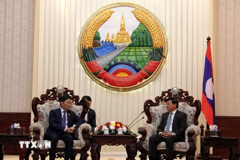 Bộ trưởng Bộ Công Thương Trần Tuấn Anh chào xã giao Thủ tướng Lào Thoongloun Sisoulith. (Ảnh: Phạm Kiên/TTXVN)