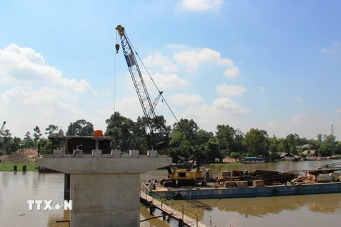 Đơn vị thi công đang đúc hoàn thiện trụ cầu Bến Đình, phần giữa sông Vàm Cỏ Đông. (Ảnh: Lê Đức Hoảnh/TTXVN)