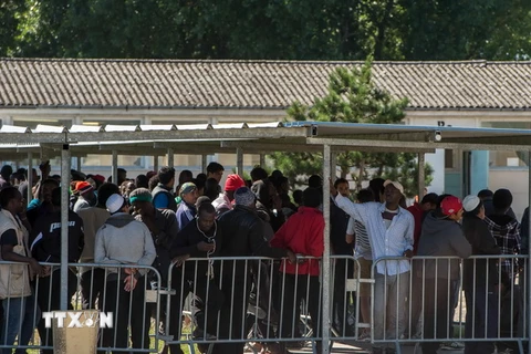 Người di cư chờ nhận khẩu phần ăn tại trại tị nạn ở Calais, Pháp ngày 22/8. (Nguồn: EPA/TTXVN)