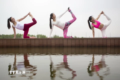Các bà mẹ trẻ tập yoga nhân Ngày của Mẹ tại một công viên ở tỉnh Giang Tô, Trung Quốc. (Nguồn: THX/TTXVN)