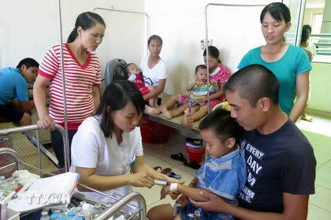 Bác sỹ thăm khám và điều trị cho trẻ bị ngộ độc thực phẩm tại Bệnh viện Nhi Nam Định. (Ảnh: Văn Đạt/TTXVN)