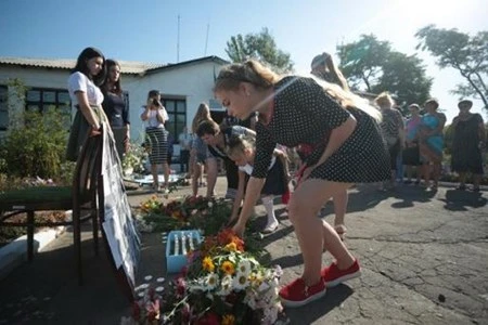 Người dân tại làng Petropavlivka đặt hoa tưởng niệm nạn nhân vụ máy bay MH17. (Nguồn: AFP)