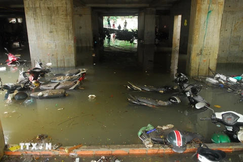 Xe máy trong bãi giữ xe trên đường Nguyễn Siêu bị chìm trong nước. (Ảnh: Mạnh Linh/TTXVN) 