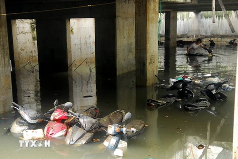 Xe máy trong bãi giữ xe trên đường Nguyễn Siêu bị chìm trong nước. (Ảnh: Mạnh Linh/TTXVN)