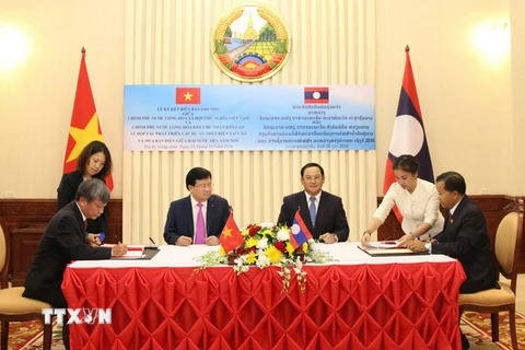 Hai Phó Thủ tướng chứng kiến lễ ký Thỏa thuận triển khai dự án “Xây dựng Trụ sở Ủy ban hợp tác Lào-Việt Nam” giữa Bộ Kế hoạch - Đầu tư hai nước. (Ảnh: Phạm Kiên/TTXVN)