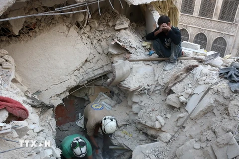 Tình nguyện viên Syria tìm kiếm người bị mắc kẹt trong những đống đổ nát sau một vụ không kích tại Aleppo ngày 4/10. (Nguồn: AFP/TTXVN)