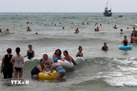 Khách du lịch và người dân đi dạo chơi, tắm biển trên các bãi biển ở Đà Nẵng. (Ảnh: Trần Lê Lâm/TTXVN)