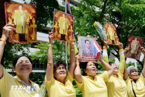 Người dân Thái Lan giơ cao chân dung Nhà Vua Bhumibol Adulyadej bên ngoài bệnh viện Siriraj ở Bangkok, nơi Nhà Vua đang nằm điều trị. (Nguồn: Kyodo/TTXVN)