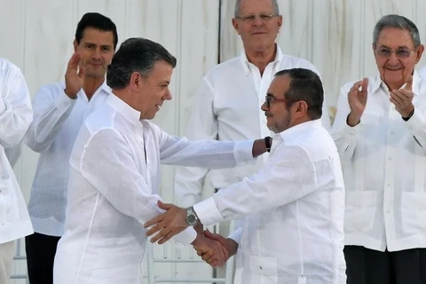 Tổng thống Colombia Juan Manuel Santos (thứ 2, trái) và thủ lĩnh FARC Timoleon Jimenez (thứ 2, phải) tại lễ ký kết thỏa thuận hòa bình ở Cartagena, Colombia ngày 26/9. (Nguồn: AFP/TTXVN)