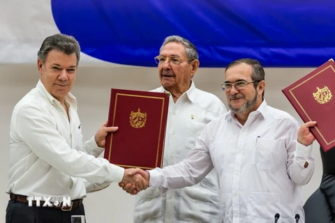 Tổng thống Colombia Juan Manuel Santos (trái, trước) và thủ lĩnh Lực lượng vũ trang Cách mạng Colombia (FARC) Timoleon Jimenez (phải, trước) tại lễ ký thỏa thuận hòa bình ở thủ đô La Habana, Cuba ngày 23/6. (Nguồn: THX/TTXVN)