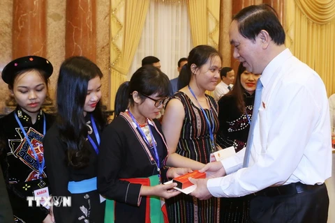 Chủ tịch nước Trần Đại Quang tặng quà cho các em học sinh, sinh viên tiêu biểu tại buổi gặp mặt. (Ảnh: Nhan Sáng/TTXVN)