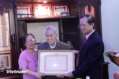 Ông Hà Anh Dân, (ngoài cùng bên phải) đang trao quyết định của Đảng Cộng sản Việt Nam tặng Huy hiệu 65 năm tuổi Đảng cho ông Trần Văn Mỹ. (Ảnh: Phạm Kiên/Vietnam+)