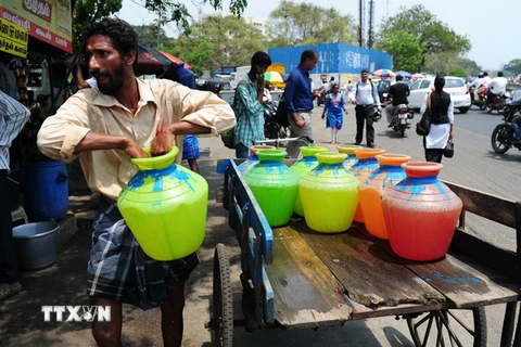 Người dân Ấn Độ xếp hàng lấy nước sạch tại một điểm phân phối nước miễn phí của Chính phủ ở Chennai ngày 22/3. (Nguồn: AFP/TTXVN)