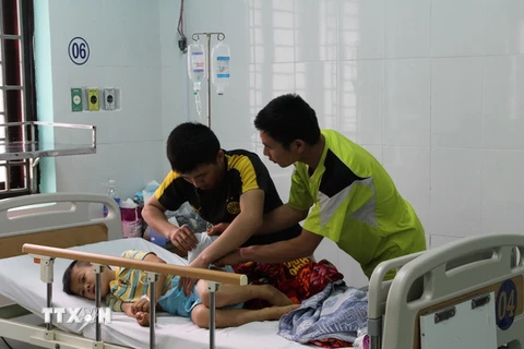 Cháu Nguyễn Giác Sáng được người nhà chăm sóc tại bệnh viện. (Ảnh: Ngọc Minh/TTXVN)