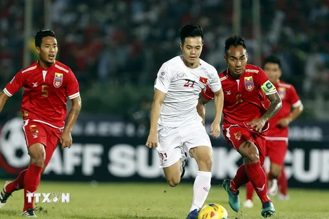 Tiền đạo Nguyễn Văn Toàn (giữa) đi bóng trước một hàng các cầu thủ Myanmar. (Nguồn: EPA/TTXVN)
