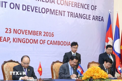 Thủ tướng Nguyễn Xuân Phúc, Thủ tướng Campuchia Samdech Hun Sen và Thủ tướng Lào Thongloun Sisoulith ký Tuyên bố chung Hội nghị CLV9. (Ảnh: Thống Nhất/TTXVN)