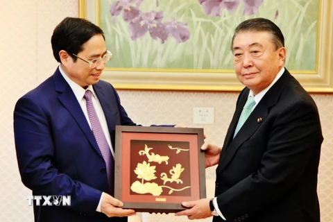 Đồng chí Phạm Minh Chính tặng quà lưu niệm cho Chủ tịch Hạ viện Nhật Bản Oshima Tadamori. (Ảnh: Gia Quân/TTXVN)