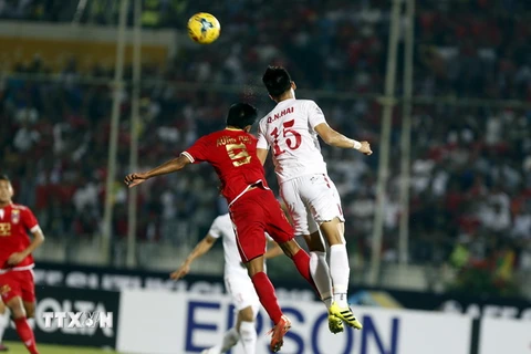 Pha tranh bóng bổng giữa hậu vệ Quế Ngọc Hải (phải) và cầu thủ Nanda Kyaw (trái) của Myanmar trong trận đấu. (Nguồn: EPA/TTXVN)