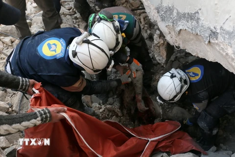 Nhân viên dân sự Syria tìm kiếm nạn nhân trong những đống đổ nát sau các vụ không kích và nã pháo tại Aleppo ngày 19/11. (Nguồn: AFP/TTXVN)