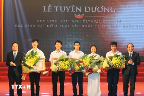 Thủ tướng Nguyễn Xuân Phúc trao tặng Bằng khen của Thủ tướng Chính phủ cho các học sinh đoạt Huy chương Vàng Olympic quốc tế. (Ảnh: Thống Nhất/TTXVN)
