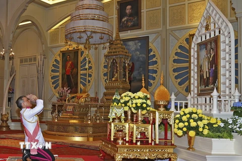 Nhà Vua mới Maha Vajiralongkorn Bodindradebayavarangkun tưởng niệm trước chân dung Nhà Vua quá cố Bhumibol Adulyadej tại lễ lên ngôi ở Bangkok ngày 1/12. (Nguồn: AP/TTXVN)
