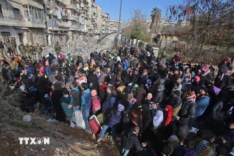 Những người dân Syria, từng phải sơ tán để tránh các cuộc giao tranh, tập trung tại điểm kiểm soát ở Maysaloun - khu vực lân cận với Aleppo ngày 8/12. (Nguồn: AFP/TTXVN)